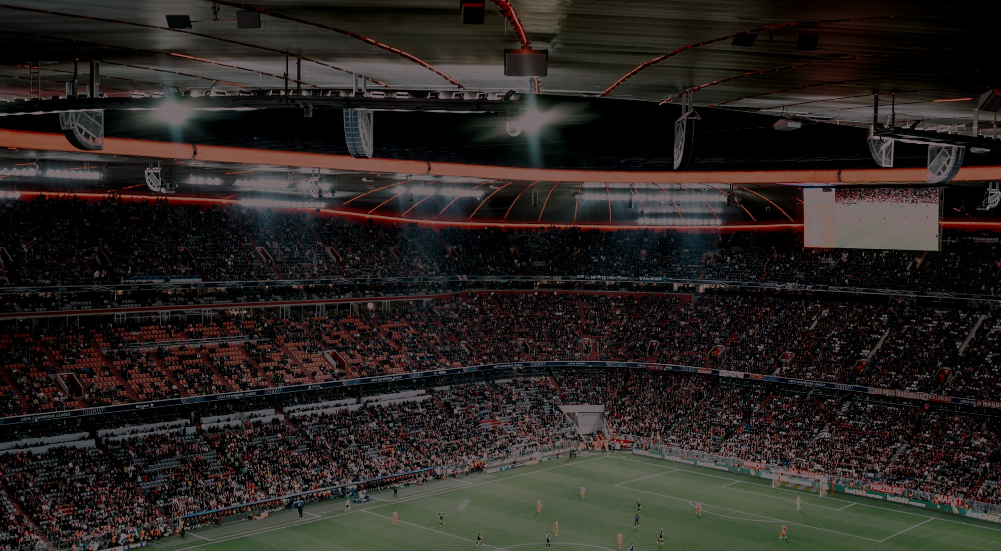 Estádio à noite com refletores acesos e arquibancada cheia